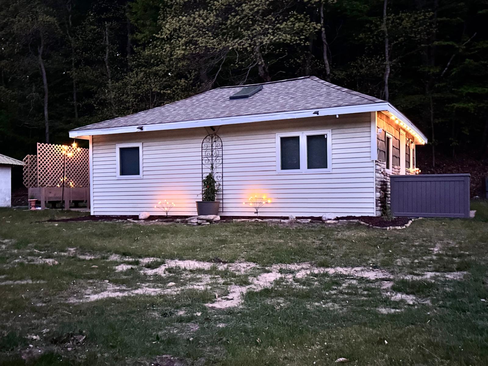 Back patio with a bistro set, umbrella, solo stove, charcoal grill and romantic string lights to enhance your stay.