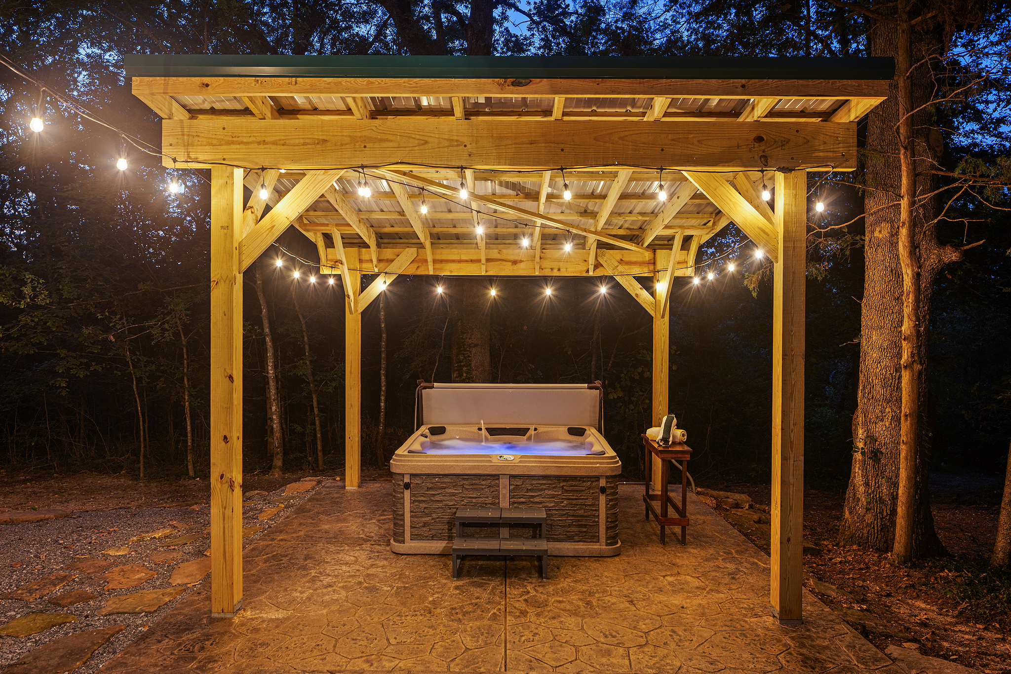 Hot tub under twinkling lights at night.