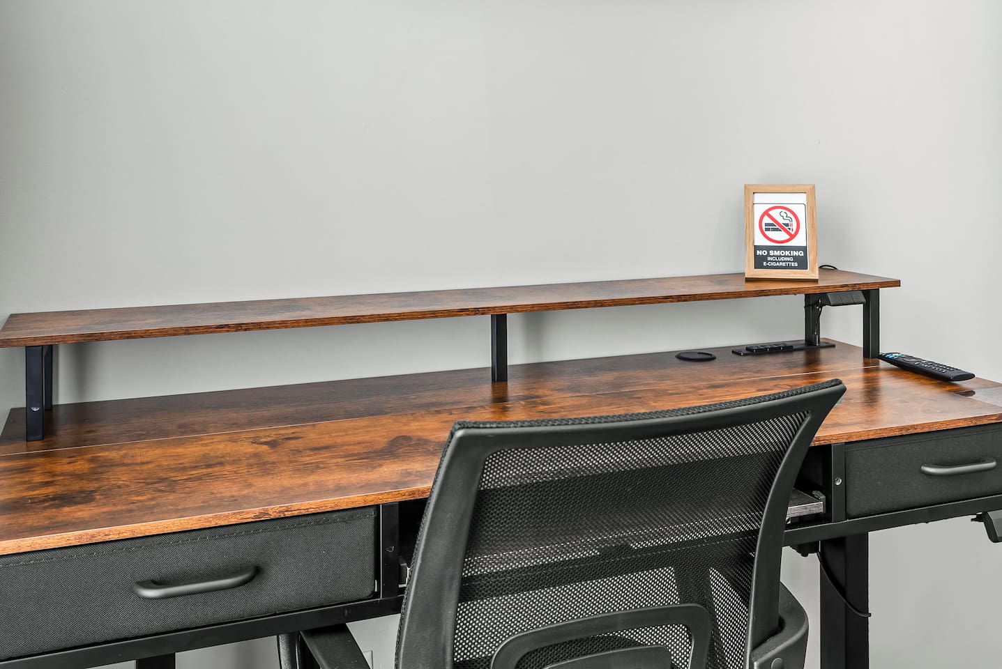 Spacious work desk with ample surface area, storage drawers, and a comfortable office chair for productive stays.