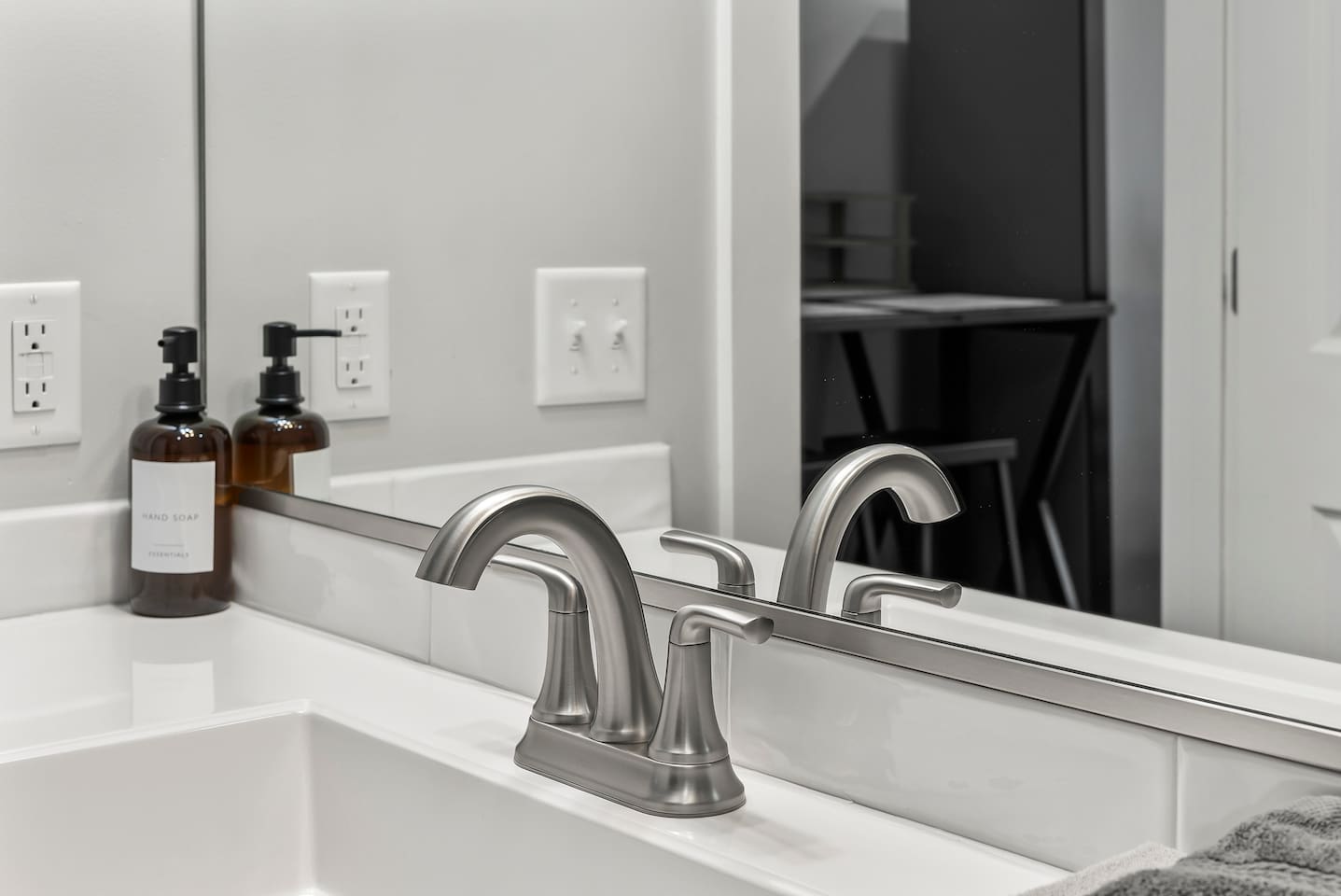 Stylish sink area with modern fixtures and complimentary hand soap.
