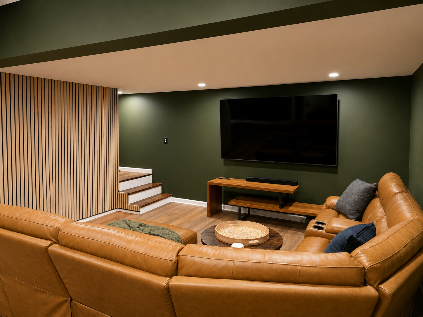 Comfortable basement living area with a large sectional, big-screen TV and open access to the game-room space.
