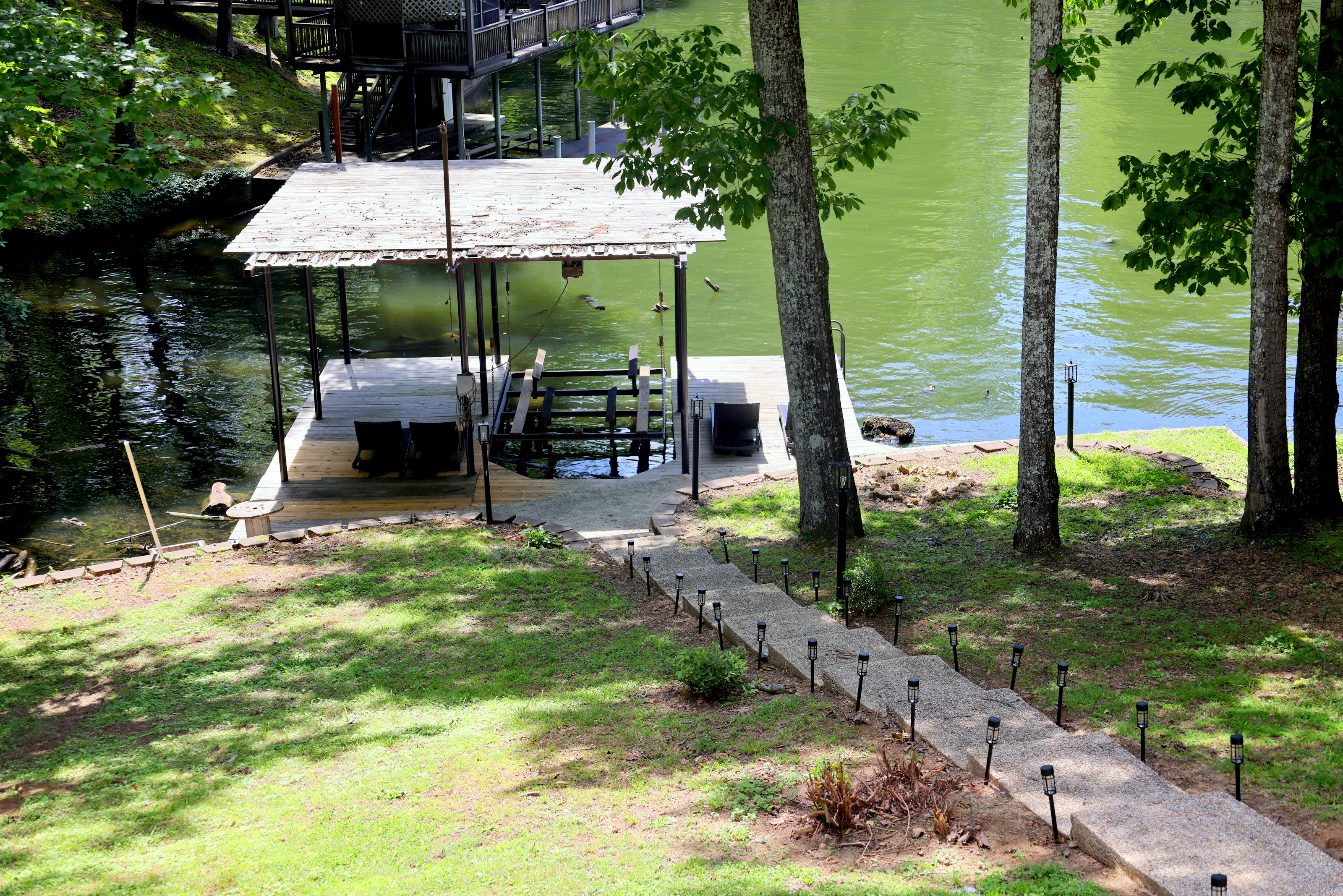 Wilson Lake waterfront view with walkway to the dock area and peaceful wooded surroundings
