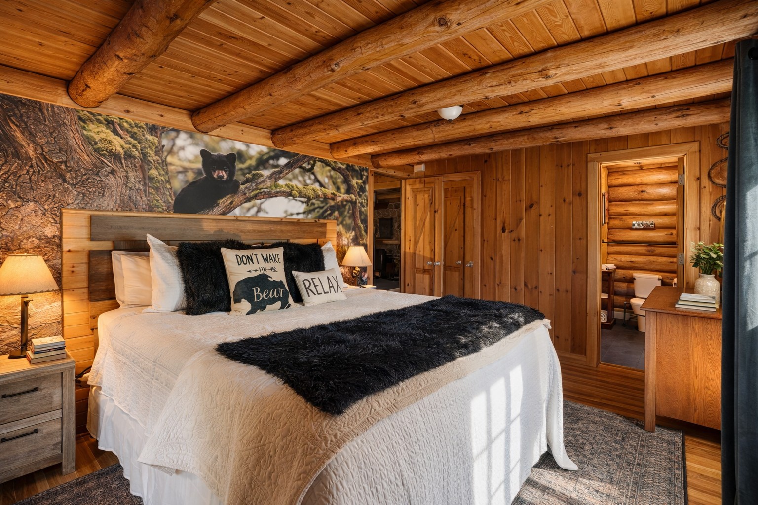 Drift off beneath the trees—our master suite features a plush king bed, rustic charm, and a custom black bear mural that brings the forest indoors.