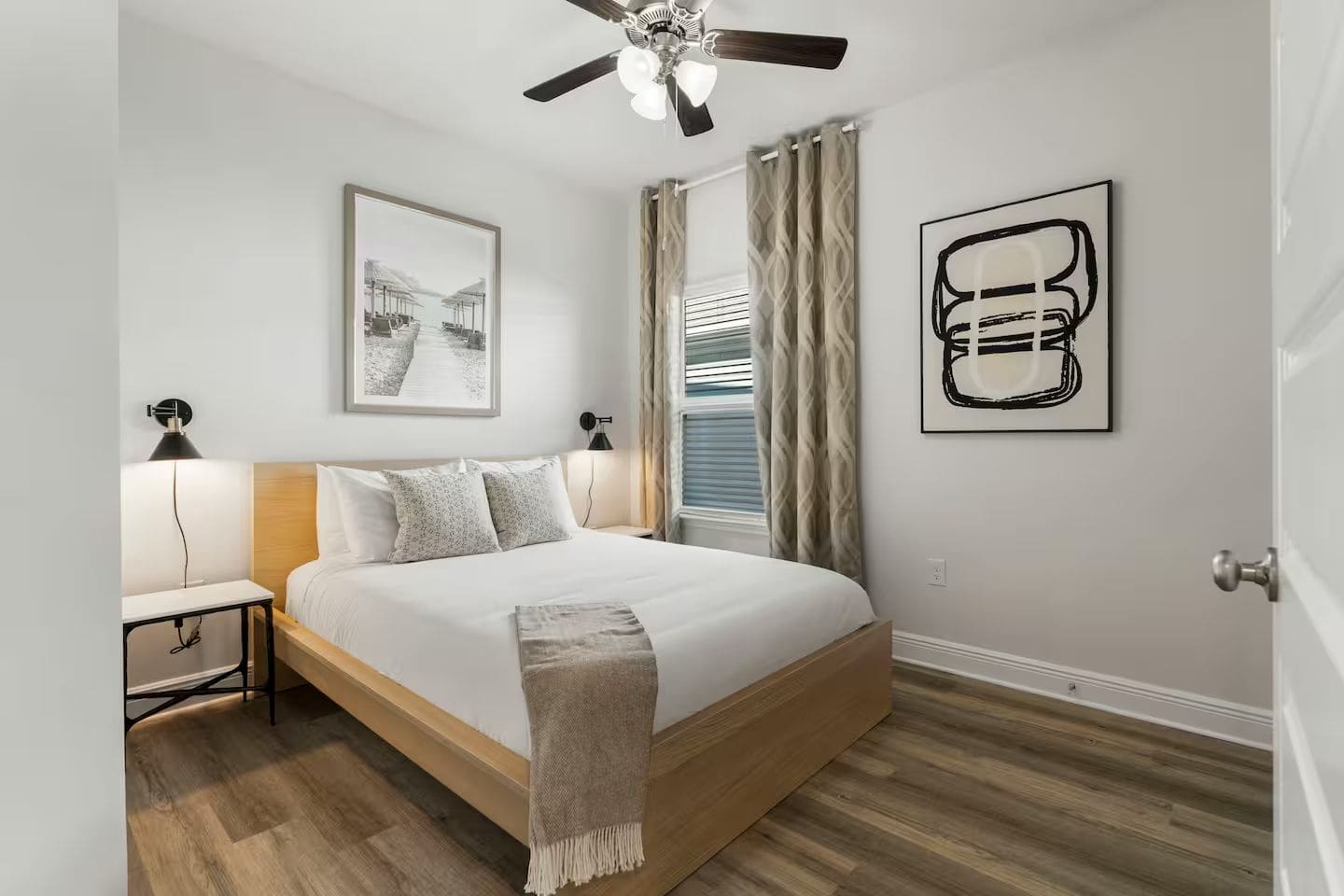 Elegant bedroom featuring a ceiling fan, natural light, and artistic touches