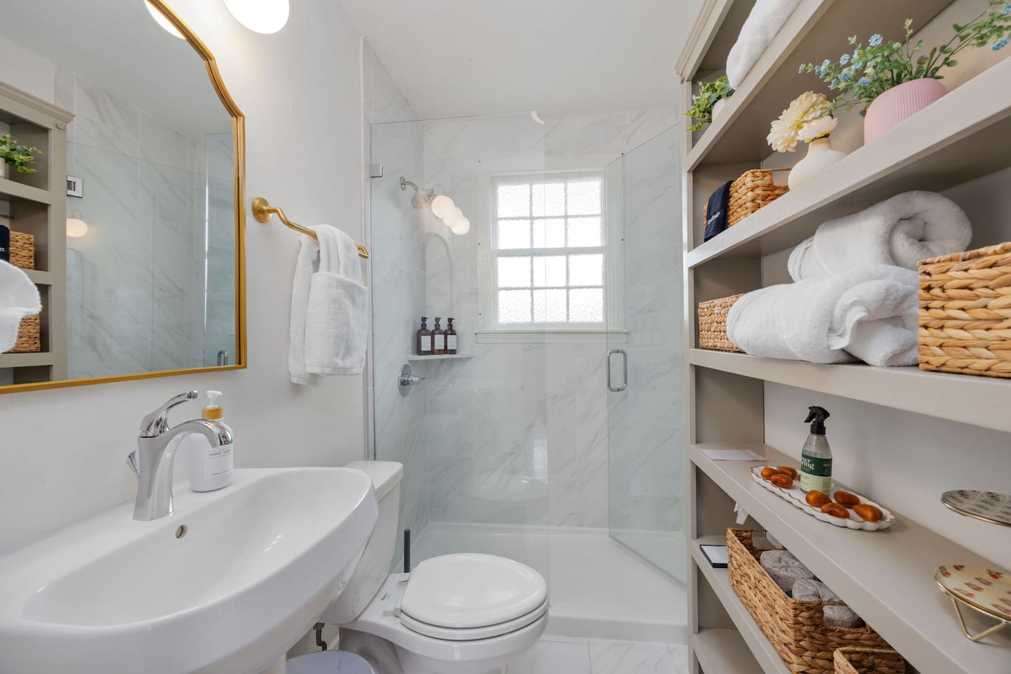 The home features one bathroom with a shower — a fresh, white space with natural light and shelving for your toiletries.