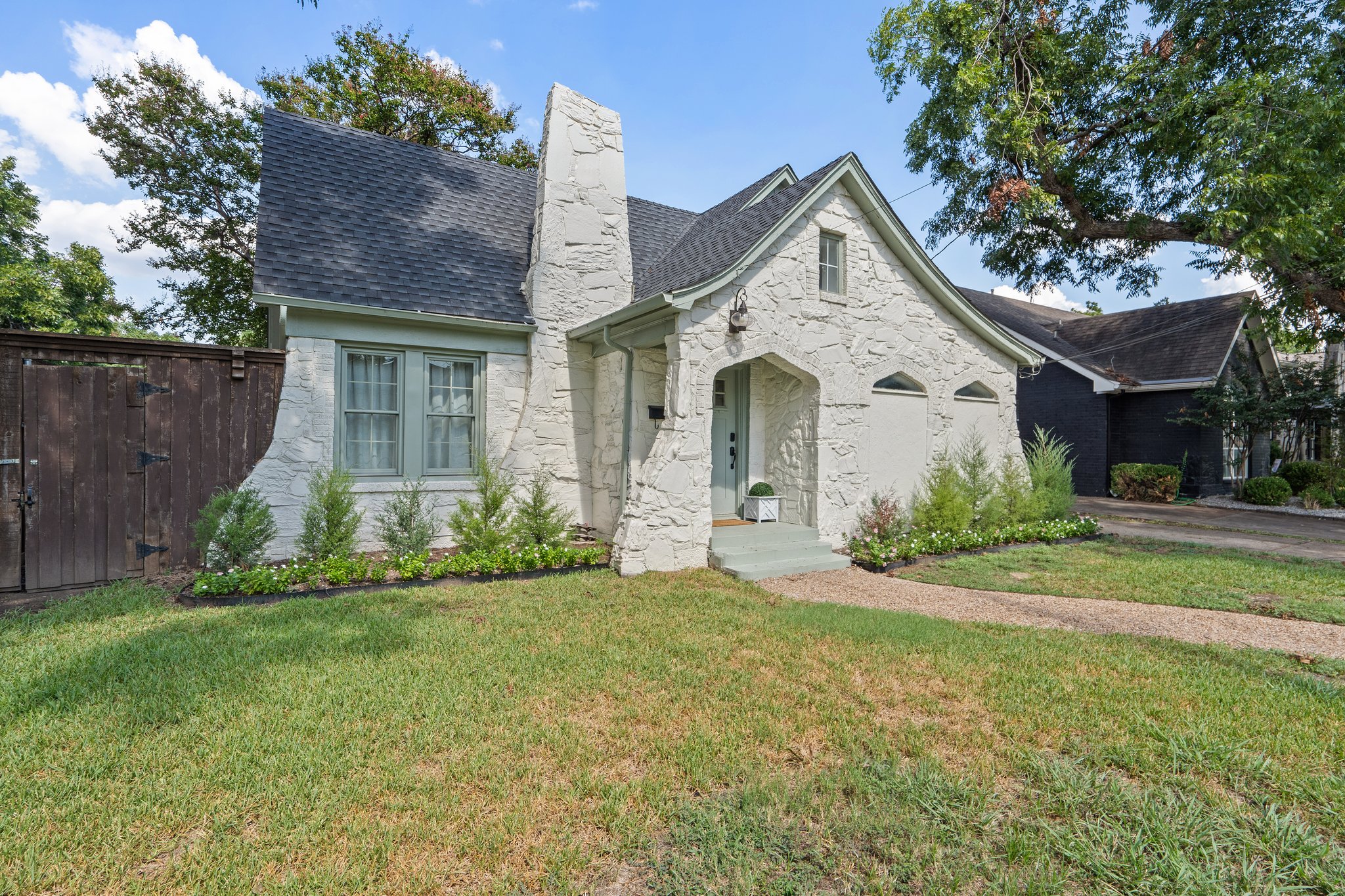 Classic 1929 stone facade with arched windows and tree-lined street. Charming curb appeal in one of Dallas's most storied residential corridors, minutes from Love Field.