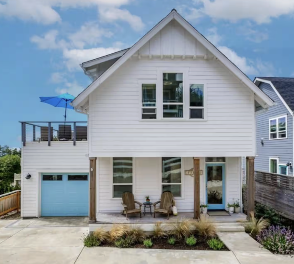 Coastal elegance at Vista Blue — a crisp white facade with serene blue accents, a private driveway, and welcoming outdoor spaces.