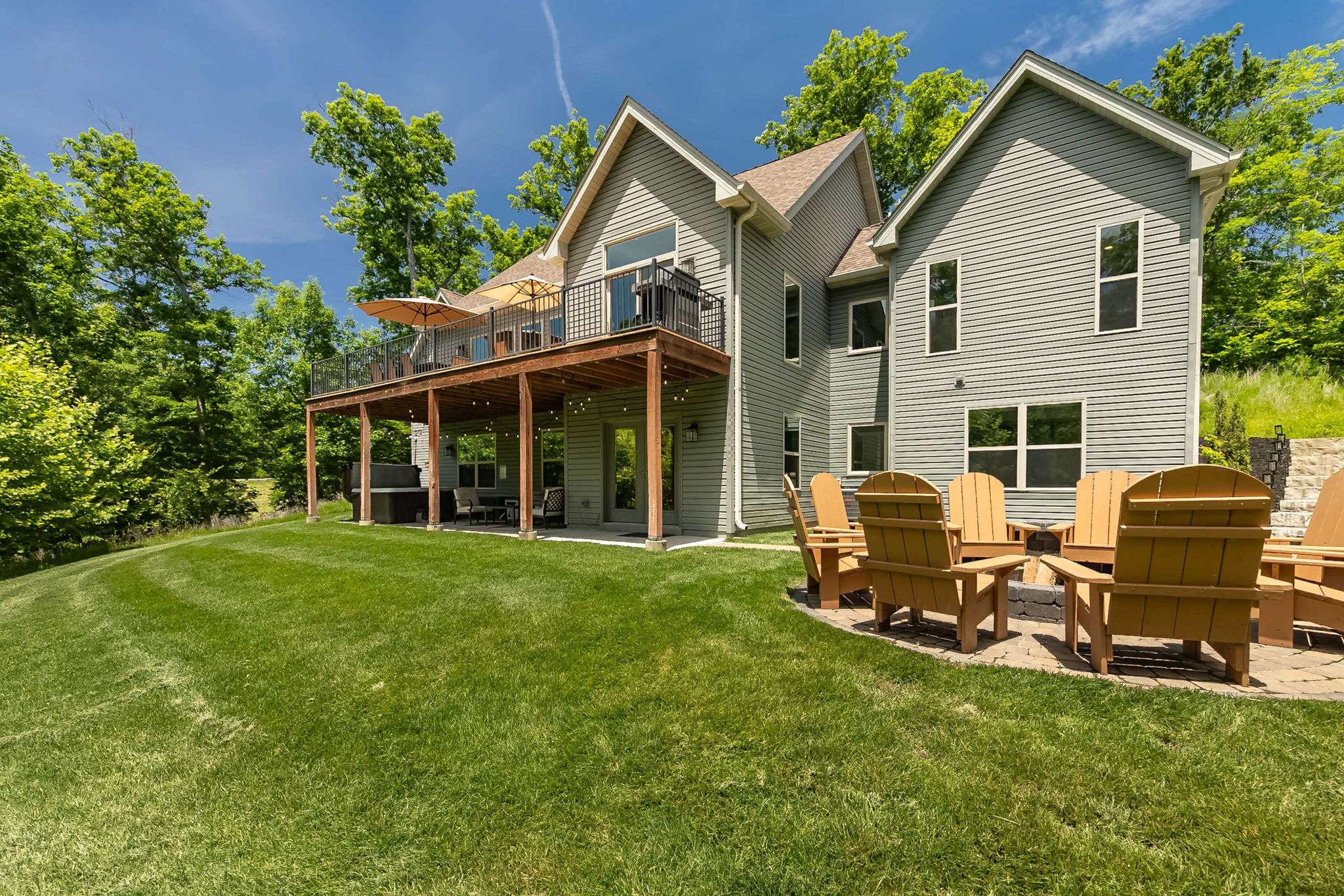The expansive lawn backs to peaceful woods for added privacy.