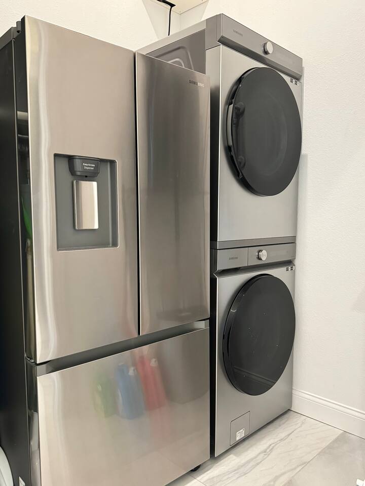 Laundry room has a stackable washer and dryer. There is even a second refrigerator with freezer for drinks in the laundry room. 