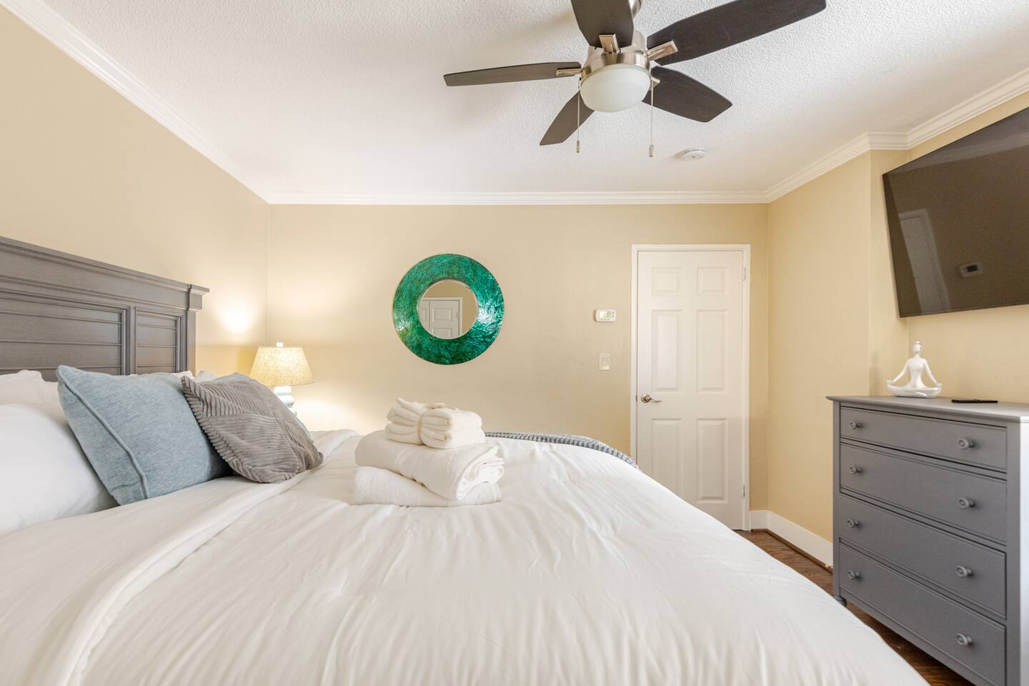 Spacious master room w/ elegant bed & soft lighting.