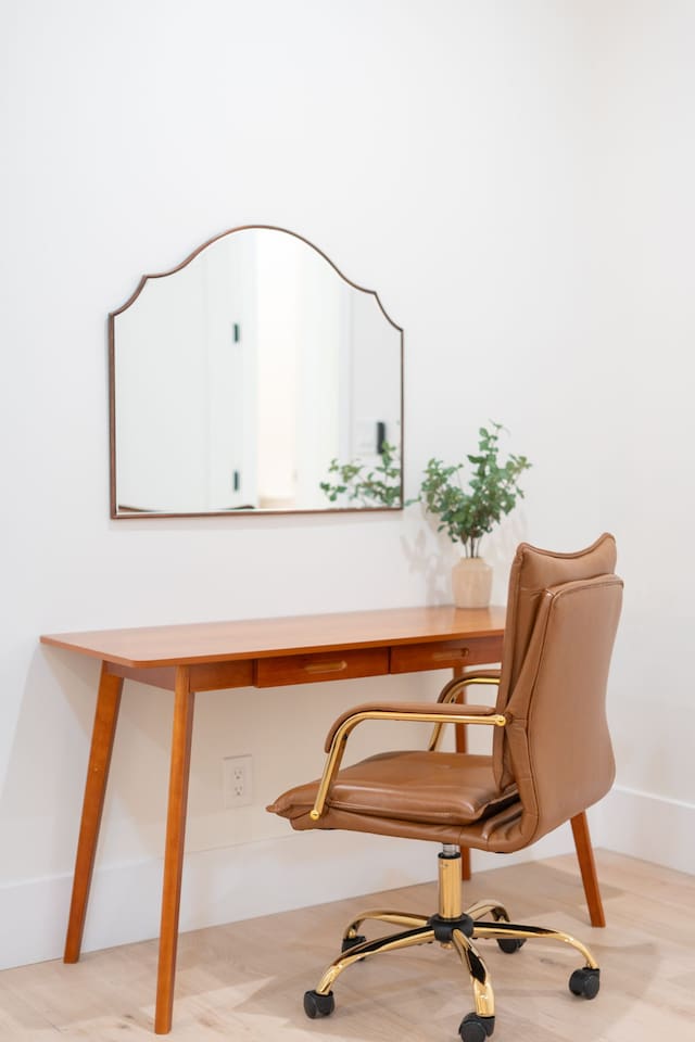 Dedicated workspace with sleek desk, leather chair, and mirror — perfect for remote work or getting ready.