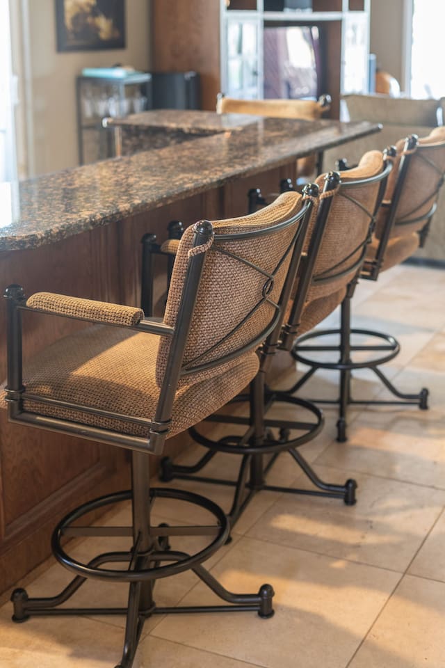 Three cushioned bar stools line the granite island — a great spot for casual meals, morning coffee, or evening cocktails.