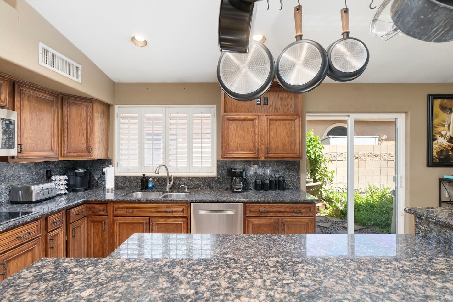 Wide granite countertops and a full cookware set give you everything you need to whip up a feast, with natural light streaming through the plantation shutters.