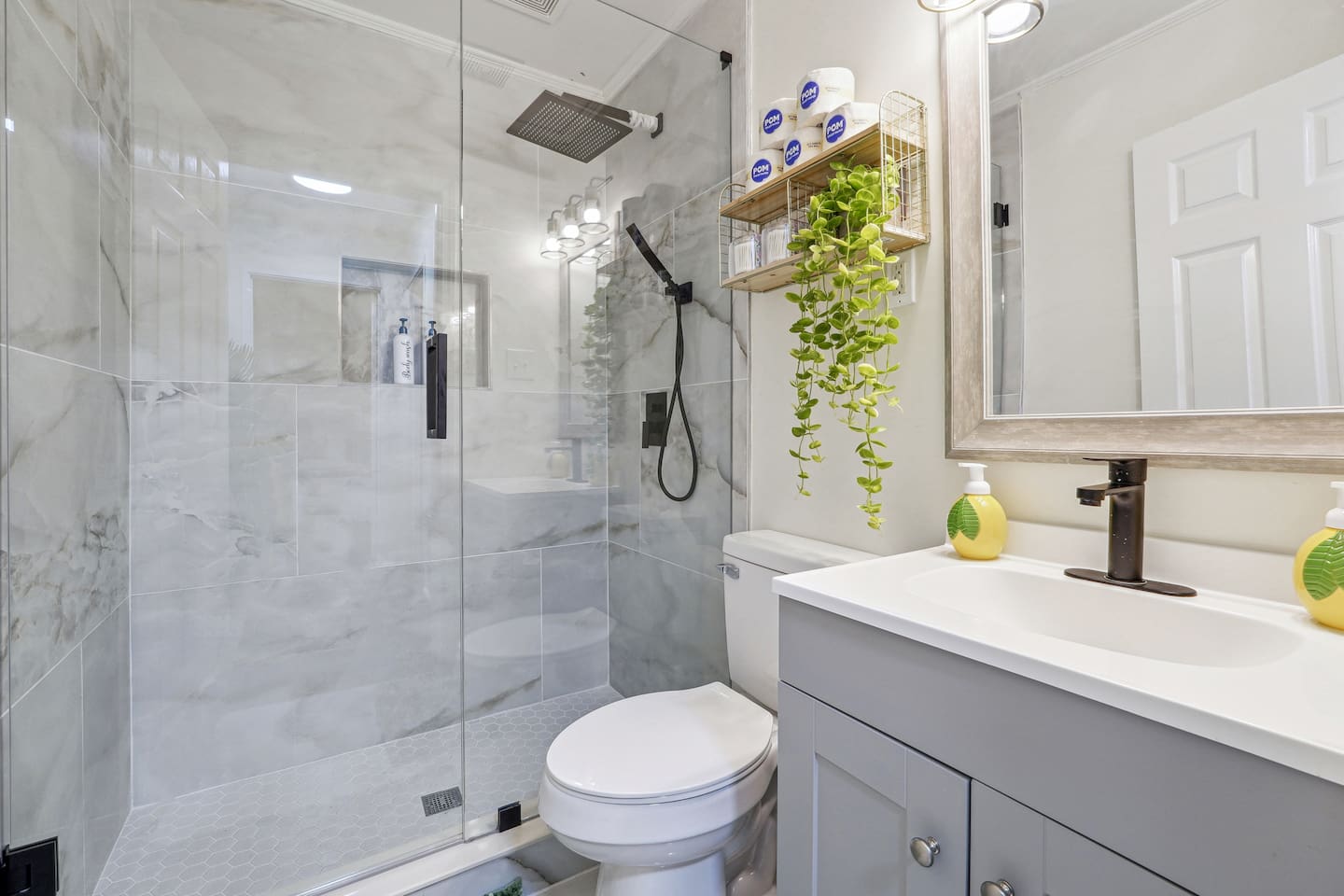 A well-equipped bathroom featuring a toilet, sink, shower with hot and cold water, toilet paper,Q-tips, shampoo, conditioner, body wash,...  everything you need for a comfortable stay.
