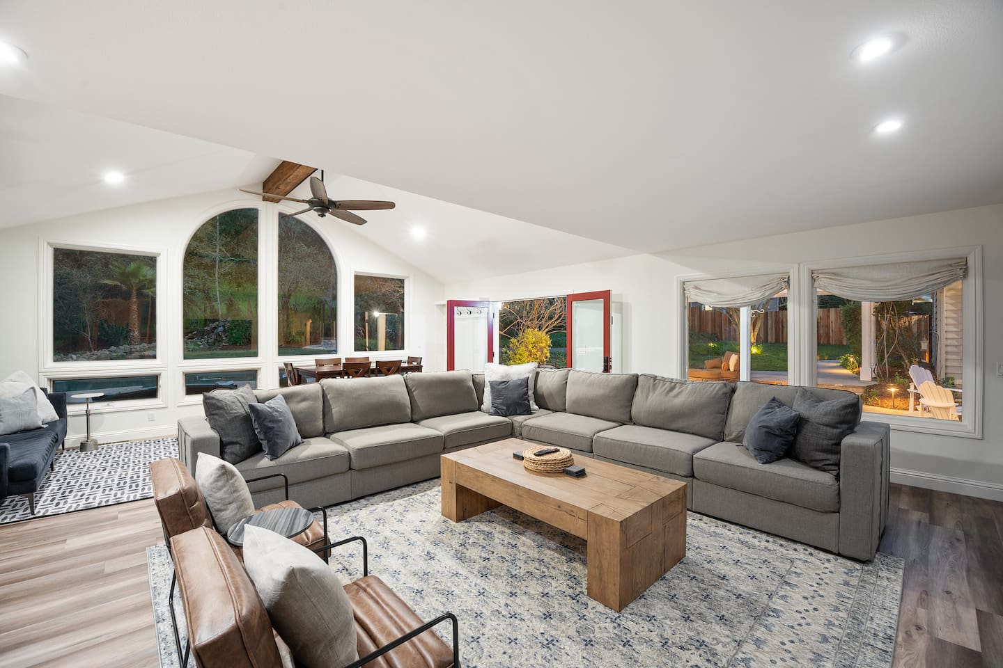 Large great room with comfortable seating for 12 adults around the 80" 4K TV. Additional couch and window seating in the second half of the room. The room also has a counter-height game table.