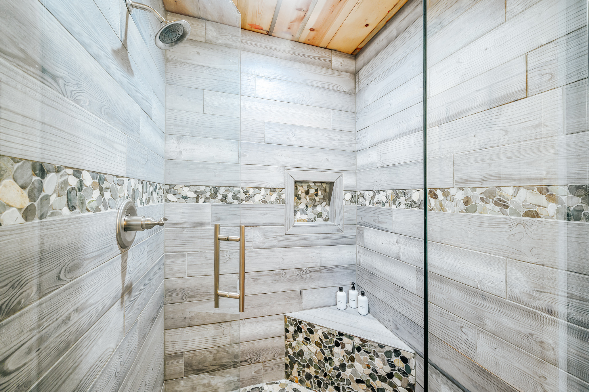 Wooden style wall shower area, glass door, shower, toilet bowl