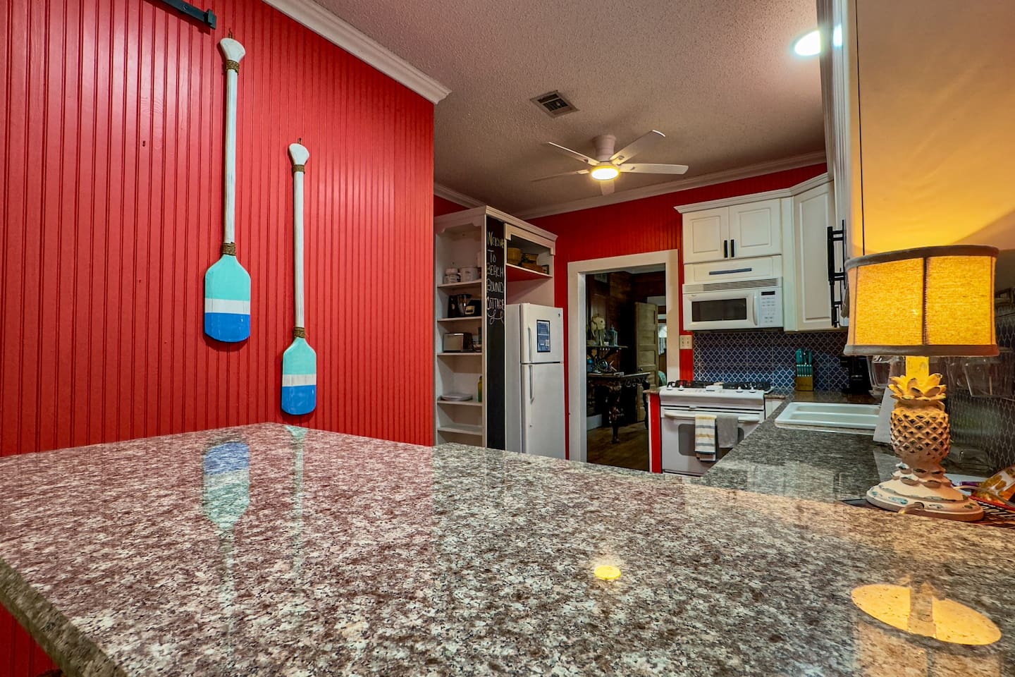 Character-filled kitchen featuring colorful design, brick flooring, and plenty of counter space for home-cooked meals.