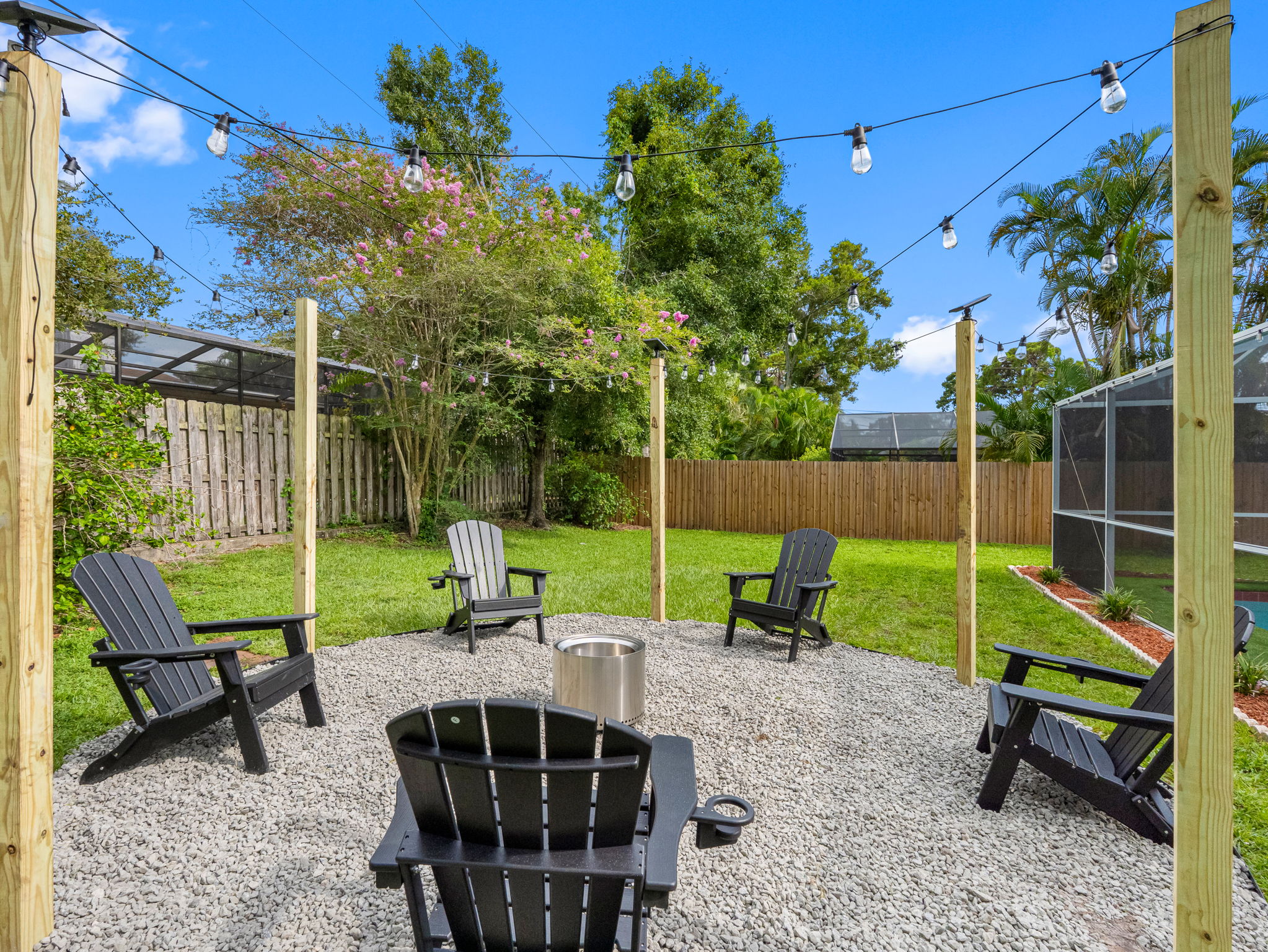 With Adirondack chairs, flickering flames, and ambient lighting, this backyard fire pit transforms nights into something magical.