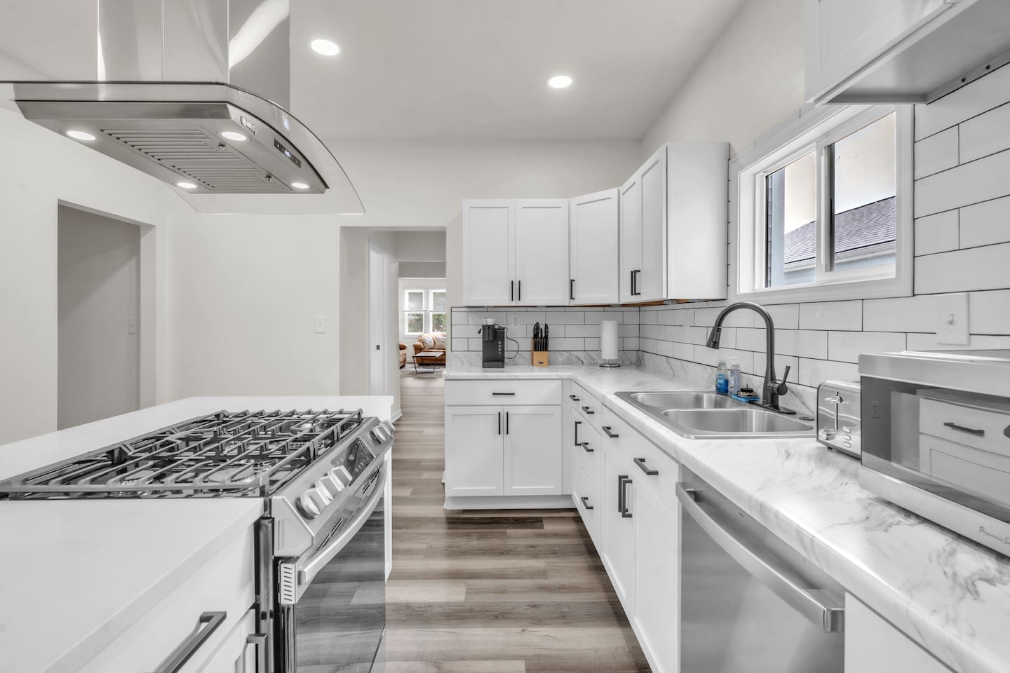 Bright and modern all-white kitchen interior, creating a clean and fresh space for cooking and dining.