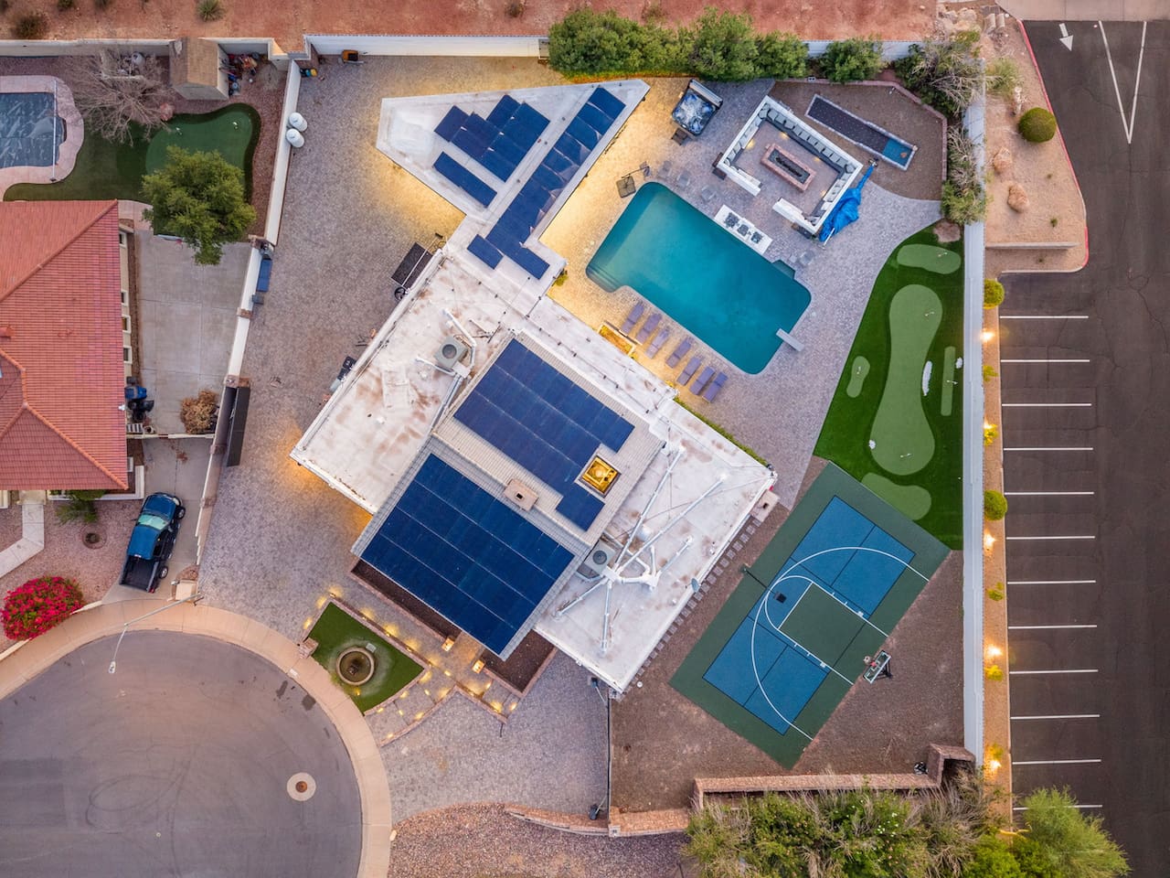 Straight-down drone view captures the pool, sport court, and solar-equipped roof — the full layout at a glance.