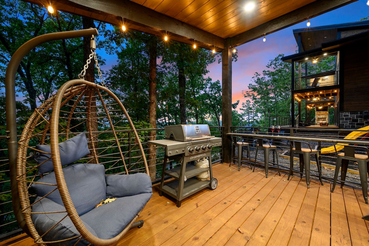 Gazebo grill, bar seating and hanging chair beside the playground.