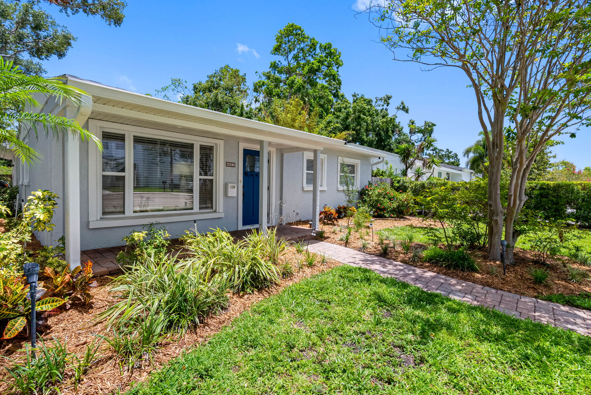 The small covered front entry provides a bit of shade and shelter, ideal for unloading luggage or simply pausing to take in the peaceful vibe of the neighborhood.