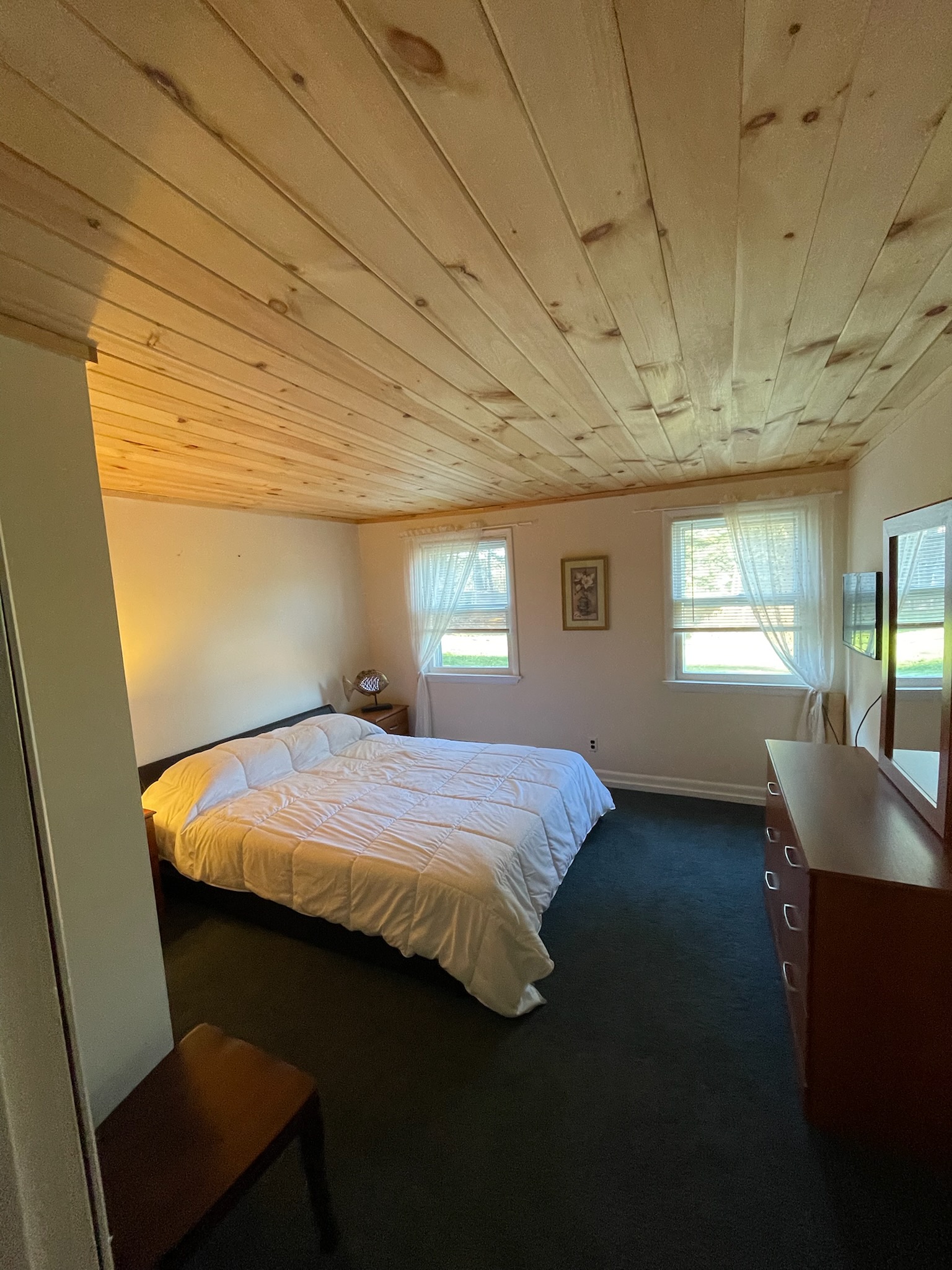 The natural wood ceiling adds a special touch to this light and airy bedroom.