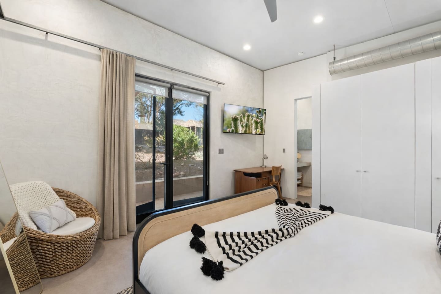 Bright bedroom with modern finishes, workspace nook, and private outdoor access.