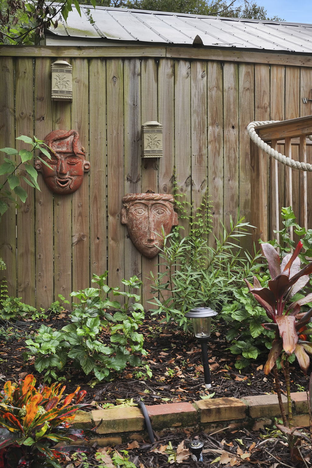 Whimsically smiling masks add charm to the backyard