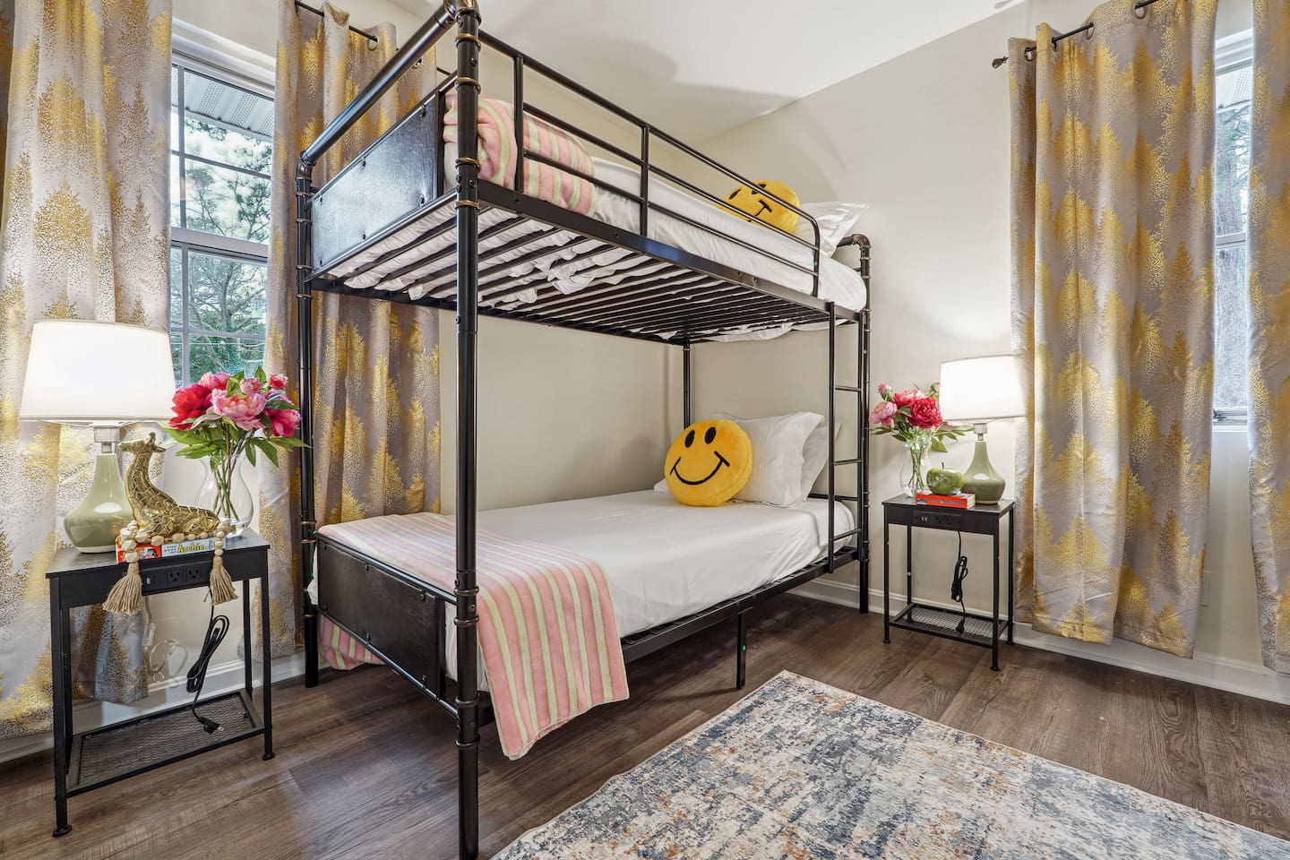 A cozy bedroom featuring a double bed, a bunk bed, a window, a bedside shelf with a lamp, and a TV — perfect for families or groups to relax and unwind.
