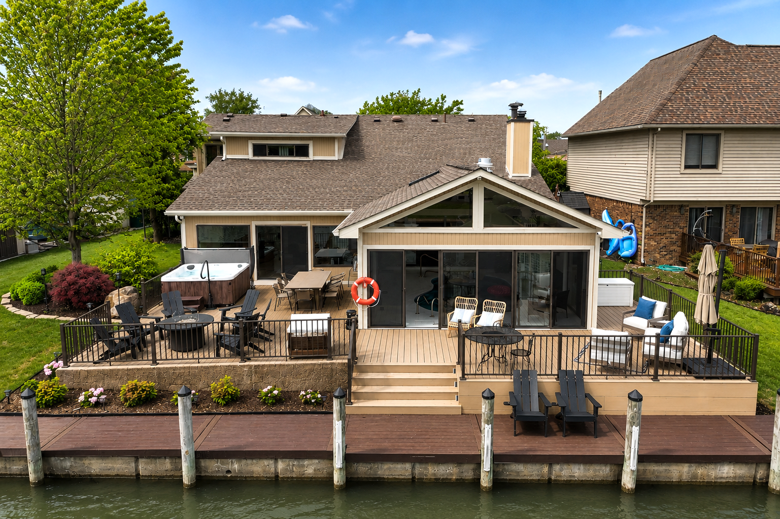 Spacious waterfront home with a large deck overlooking the canal. Features outdoor seating, dining area, and direct water access—perfect for relaxing, entertaining, and enjoying lakefront living.