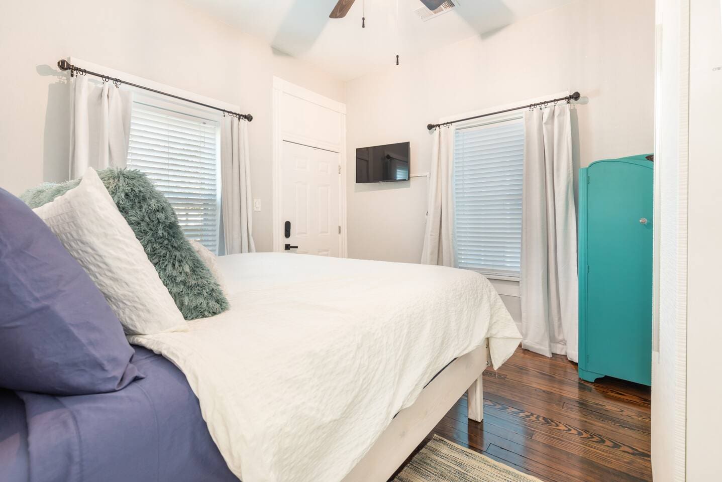 Master bedroom with king sized bed and direct access to spacious back yard with jacuzzi, fire pit, grill, deck, and patio.