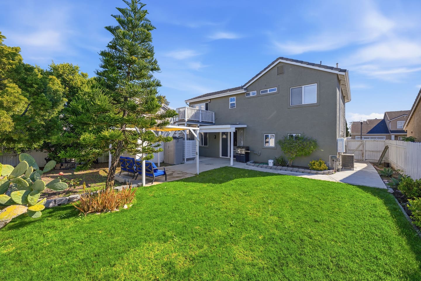 Fenced backyard with pergola, propane BBQ, and patio seating. Ideal for outdoor dining and group gatherings near Channel Islands Harbor.