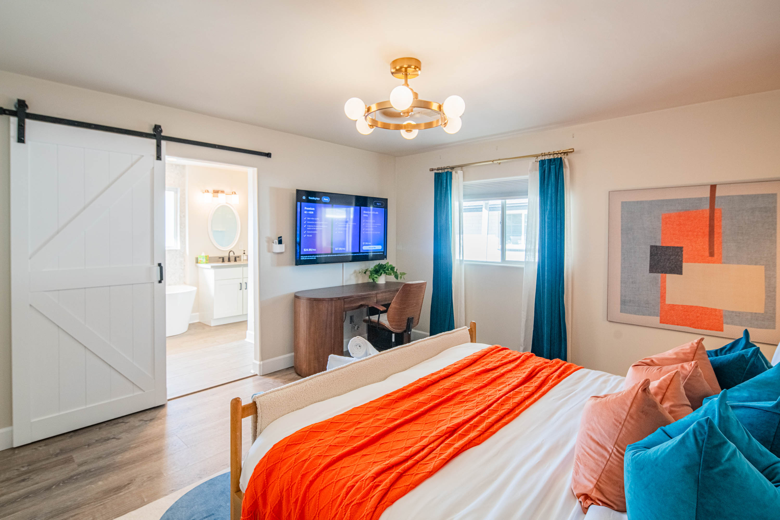 Relax in the primary bedroom featuring a king bed, modern décor, plush linens, and a calm retreat feel after a full day exploring Scottsdale.