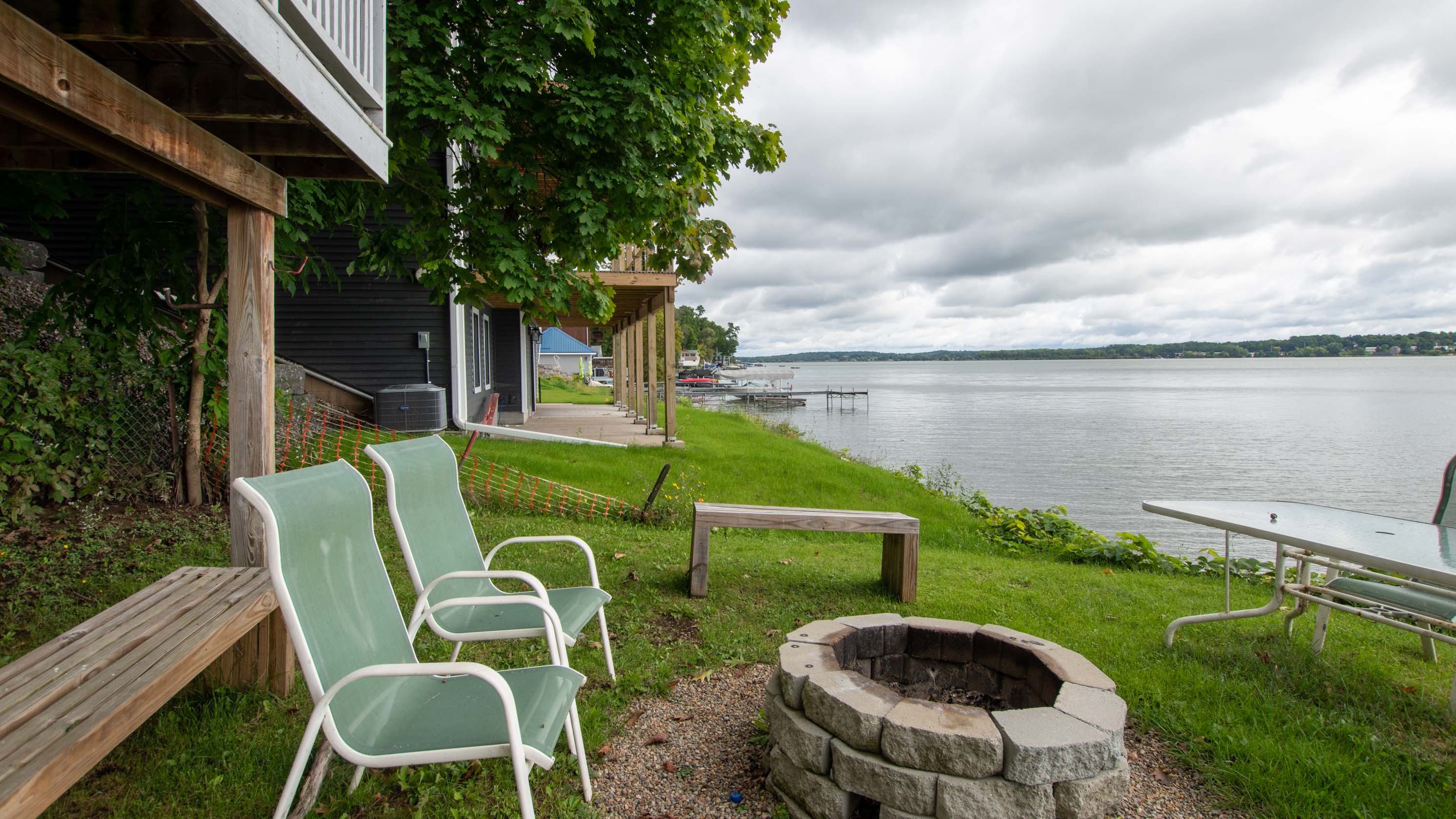Grassy lakeside yard with chairs for front-row water views.