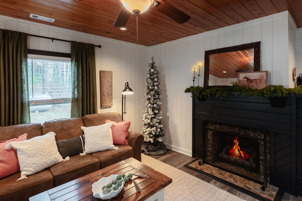 Soft winter greens, twinkling lights, and simple seasonal touches make the entry feel warm the moment you arrive. Step inside, and the living room wraps you in that same holiday magic, soft, lights, layered textures, and a glow that feels just right!