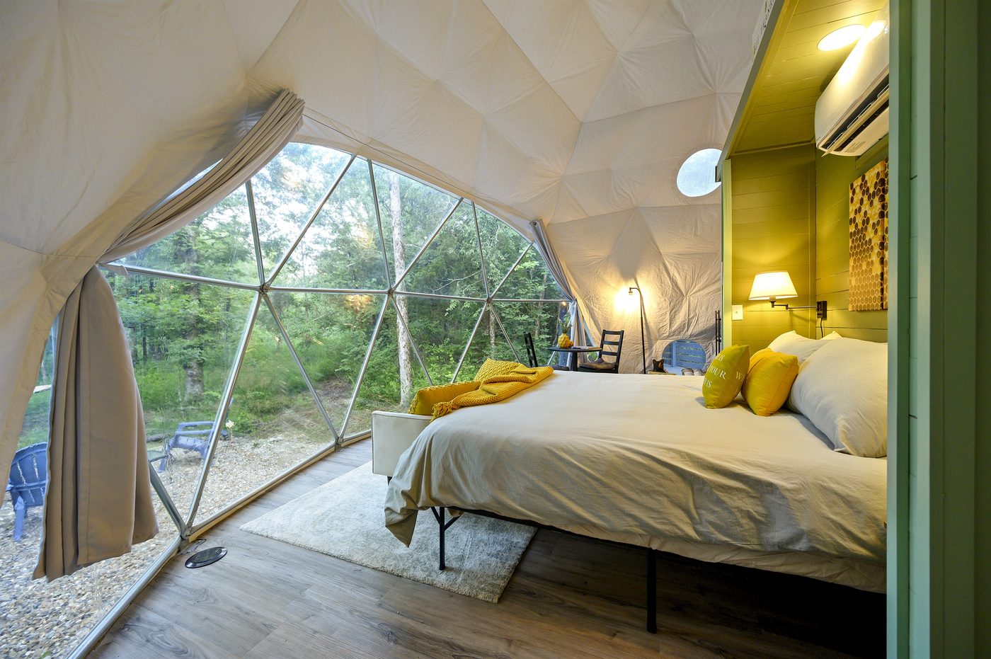 King bed facing the forest picture window inside The Honey Dome