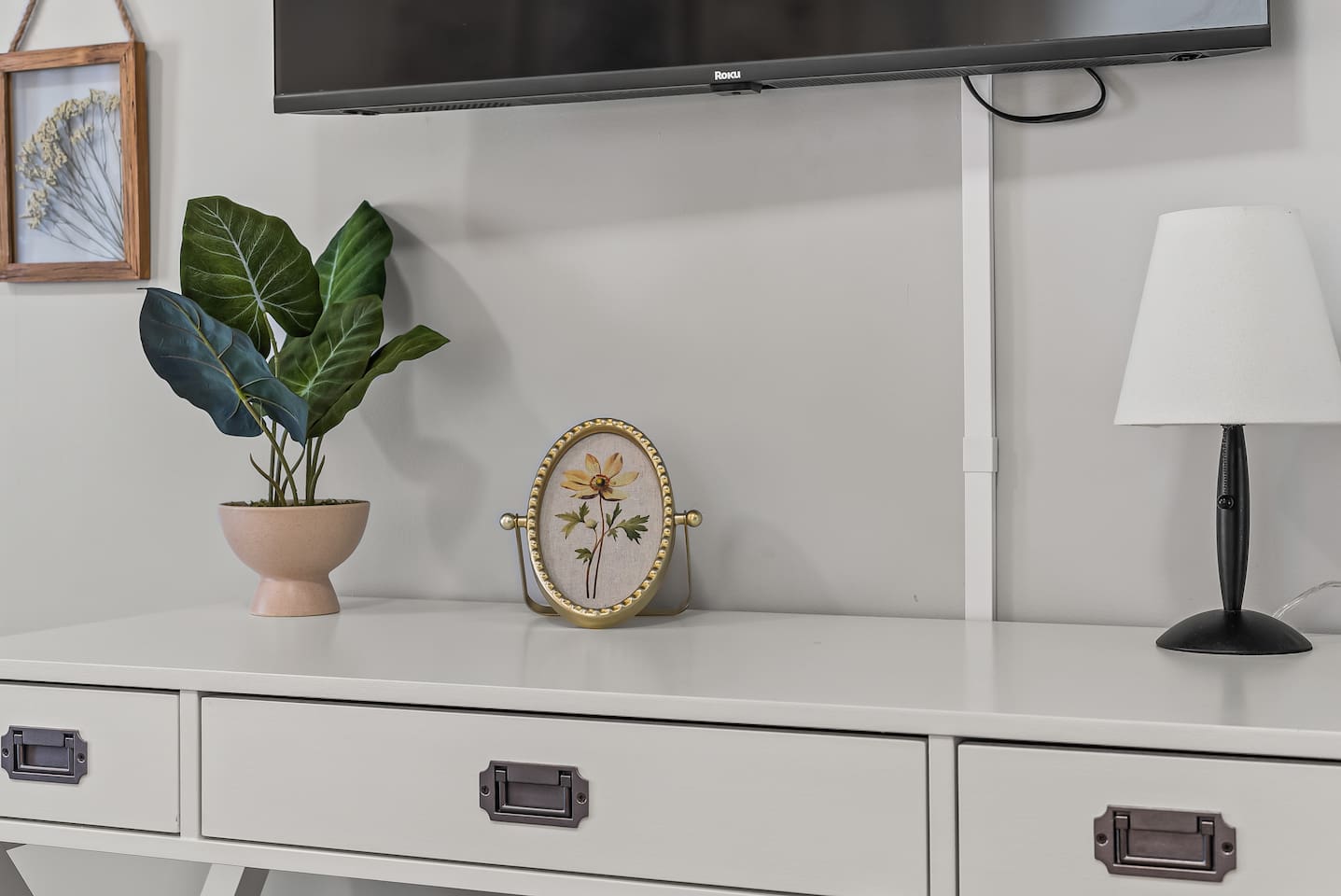 Little touches like fresh greenery and a mounted TV make this space feel like home.