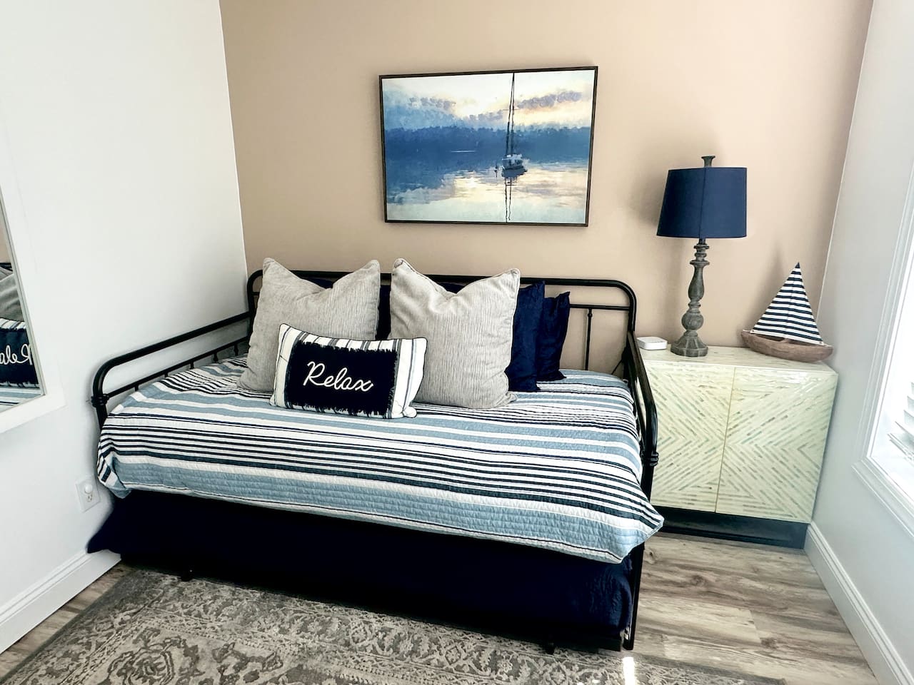 Unwind in this charming coastal-themed nook featuring a versatile daybed with a pull-out trundle. Perfect for extra guests or a quiet afternoon nap, the space is complete with nautical decor and a "Relax" pillow to set the vacation mood.