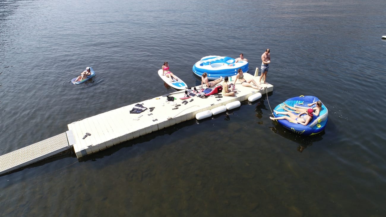 Aerial view of the dock with family swimming and using lake floats