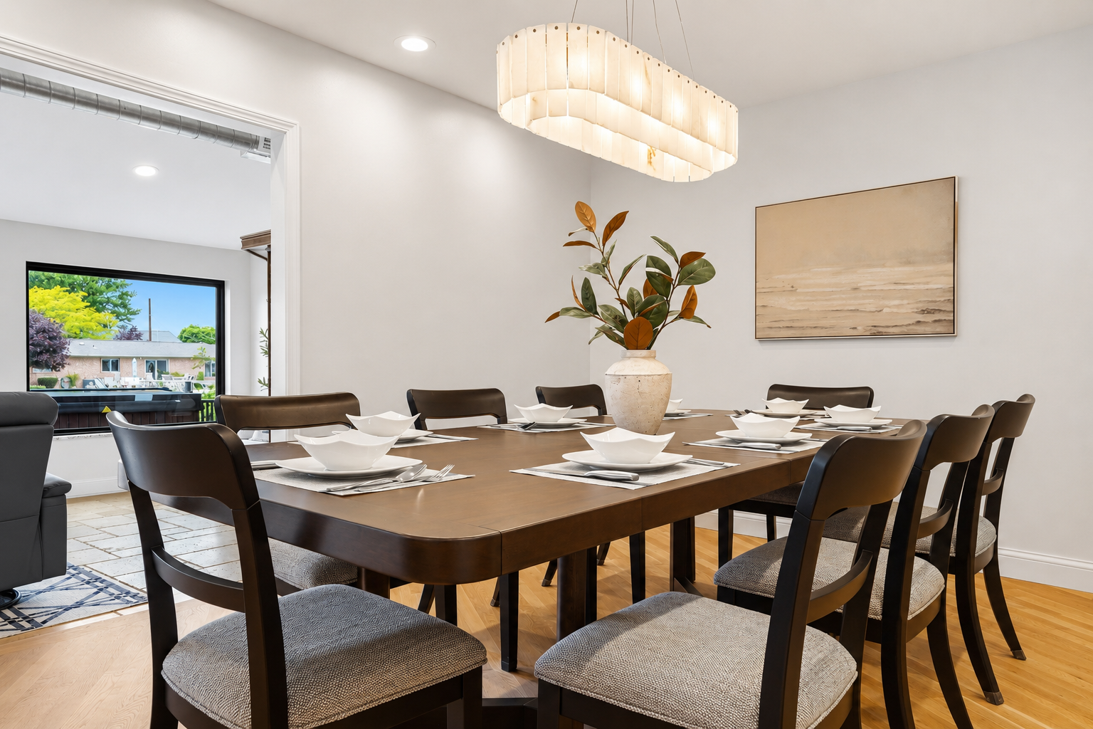 Elegant dining room with a large table, modern seating, and a bright chandelier perfect for meals, gatherings, and entertaining in a stylish, open space.