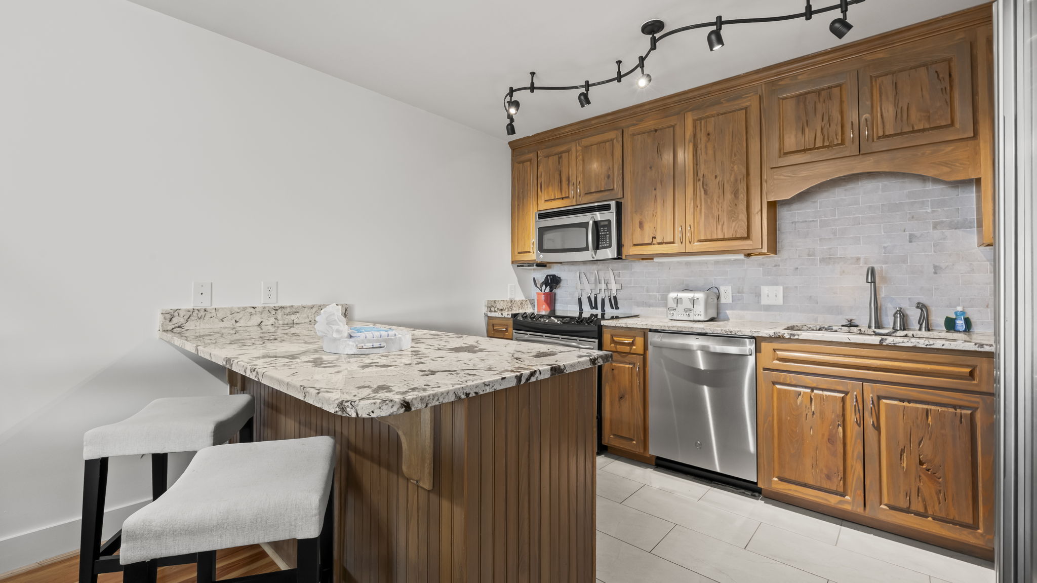 Prepare meals in the updated kitchen of our Cotton Bayou condo, featuring modern appliances, a stylish peninsula with extra seating, and a functional layout. Perfect for gathering and enjoying time with family and friends.
