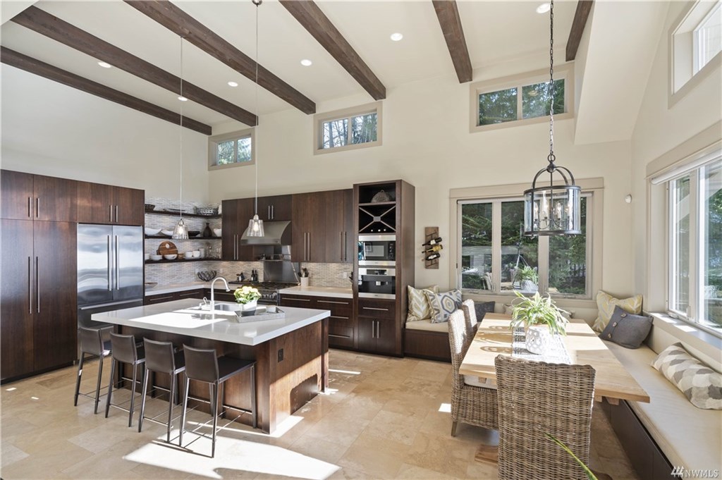Spacious dining area and kitchen with island seating for four and a dining table for ten.