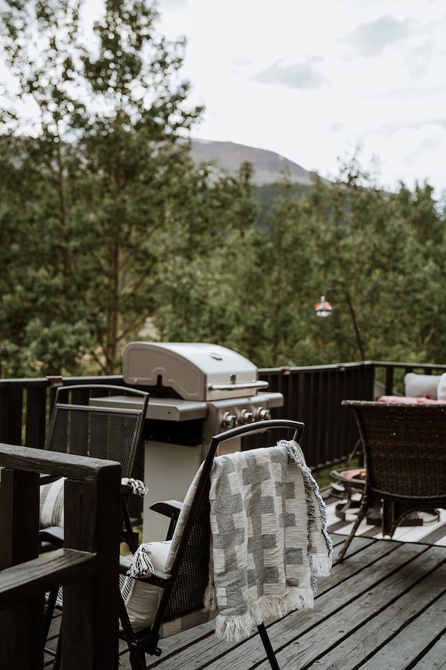 Grill, an outdoor table, gas fire table, sofa and views of the surrounding mountains and river. 