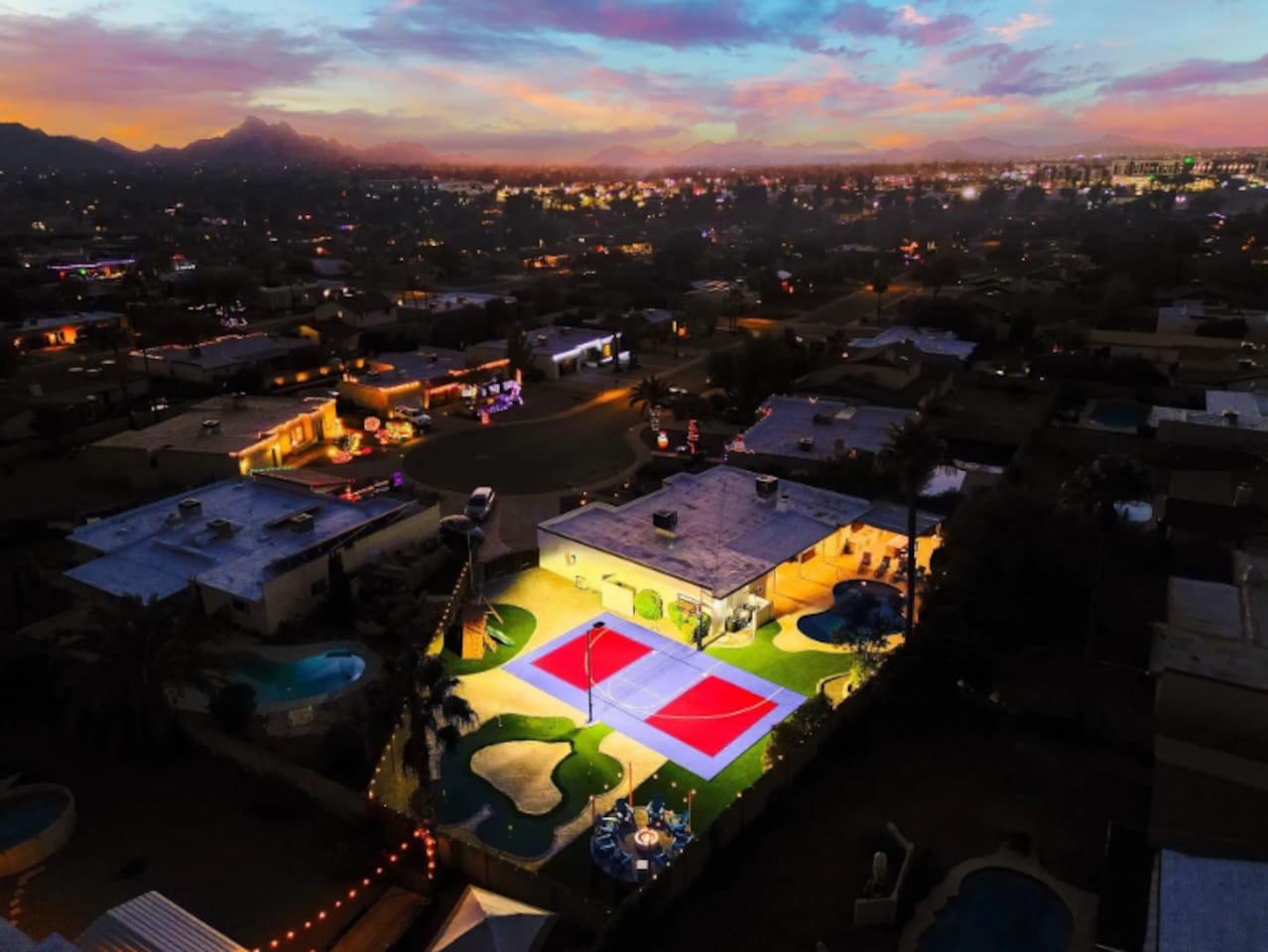 Pool, court, and putting green all visible in one frame — the kind of layout that lets everyone do their own thing at once.