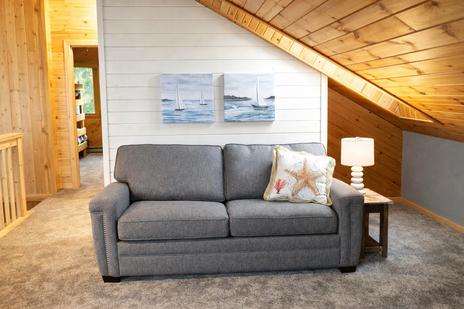 A cozy loveseat sits in the open loft, creating a perfect little retreat on the way to the second-floor bedroom. Bright, airy, and inviting, it’s an ideal spot to relax, read, or take in the peaceful cabin vibe above it all.