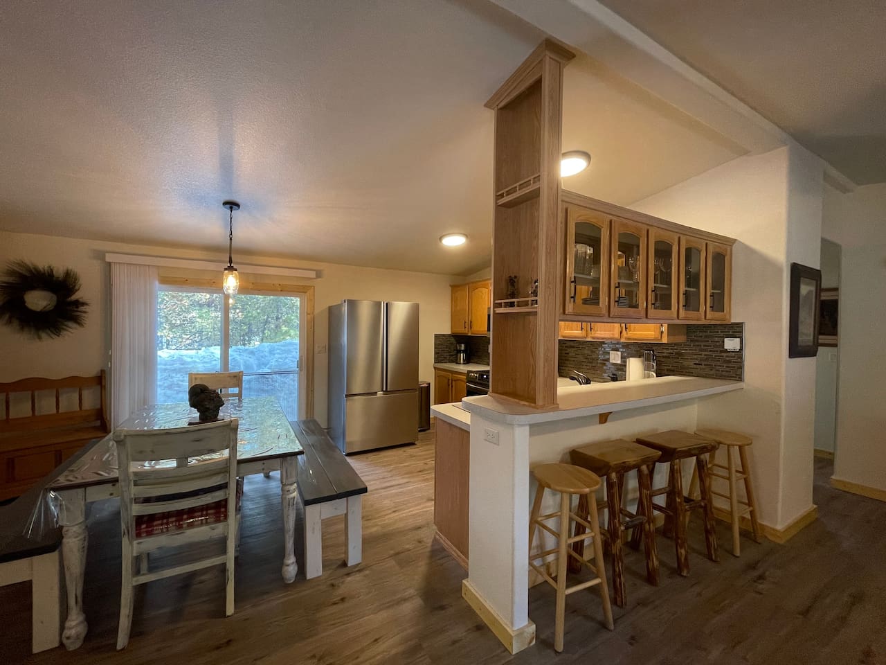 Kitchen with Updated Appliances, Backsplash, Faucet, Cupboard Door Handles, Light, Table, and Flooring