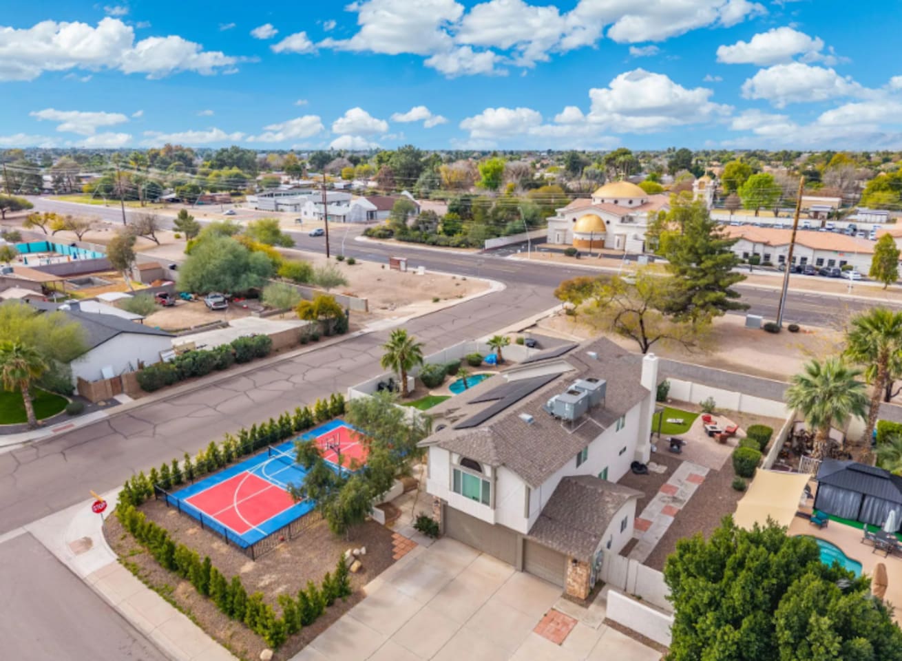 Contemporary home with dedicated sports court, pool, and manicured grounds in established neighborhood.
