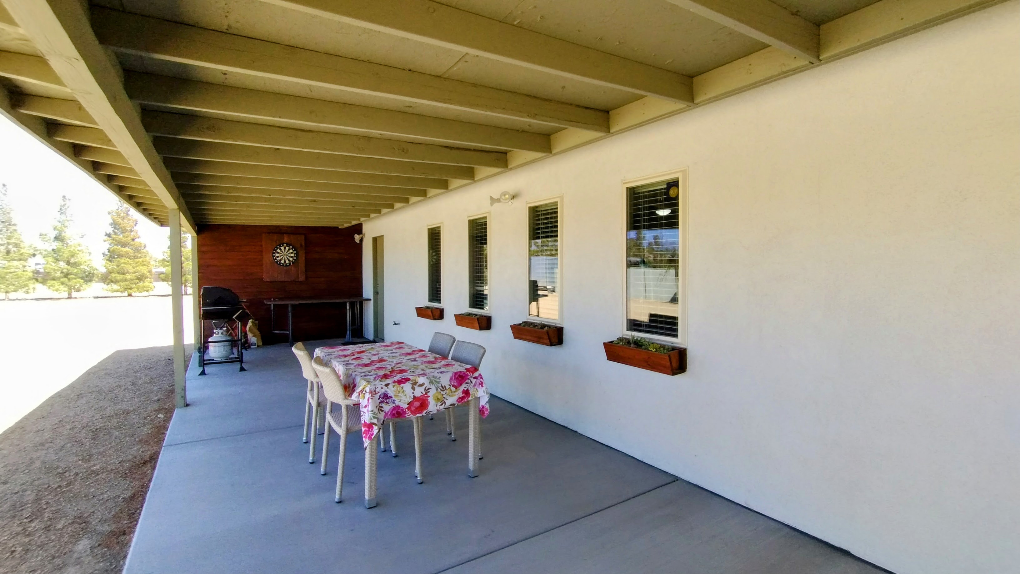 Outdoor patio dining area with grills, darts, smart tv and more seating