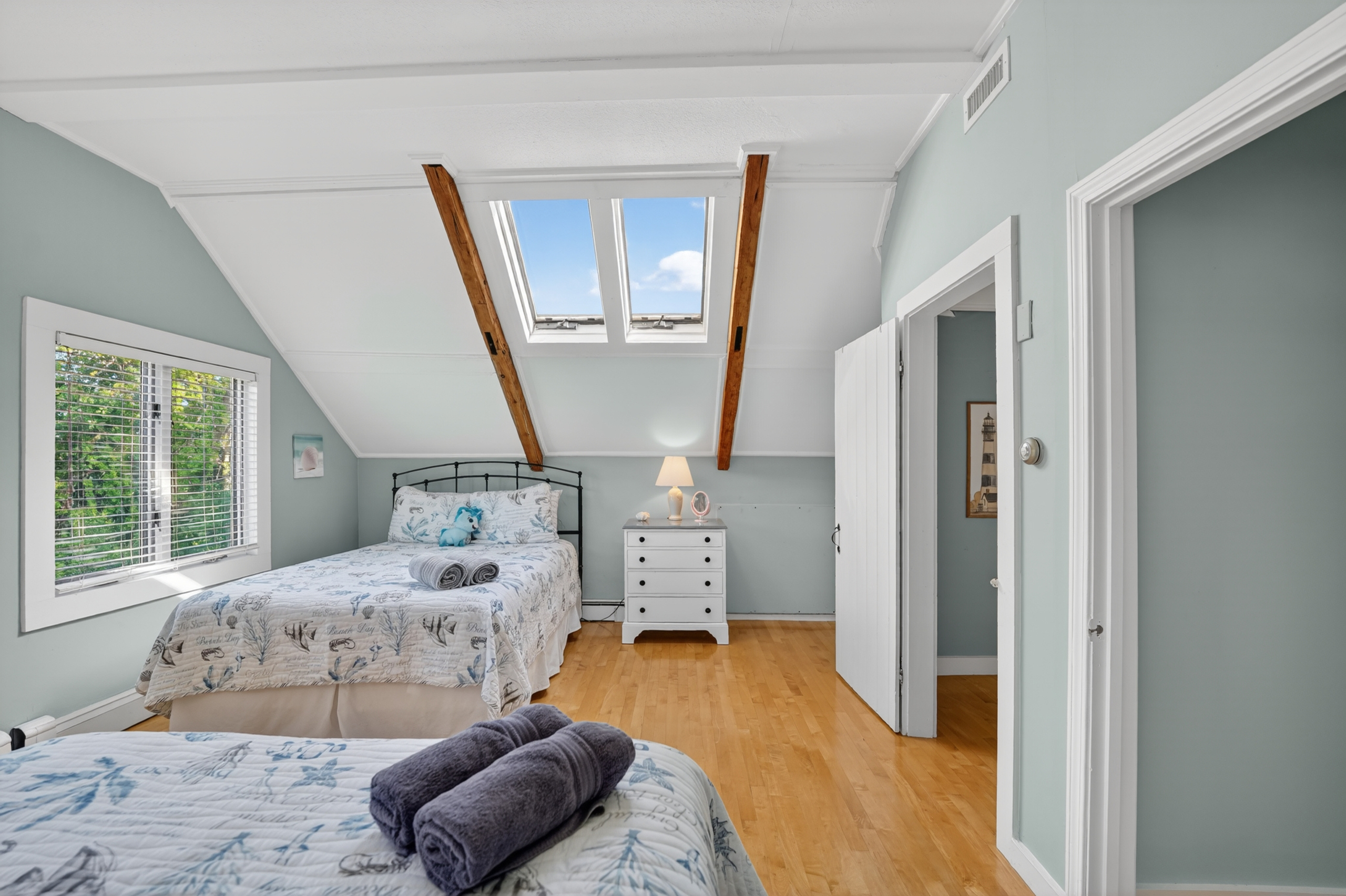 Bright upstairs sleeping area featuring comfortable accommodations, skylights, and an airy open layout.